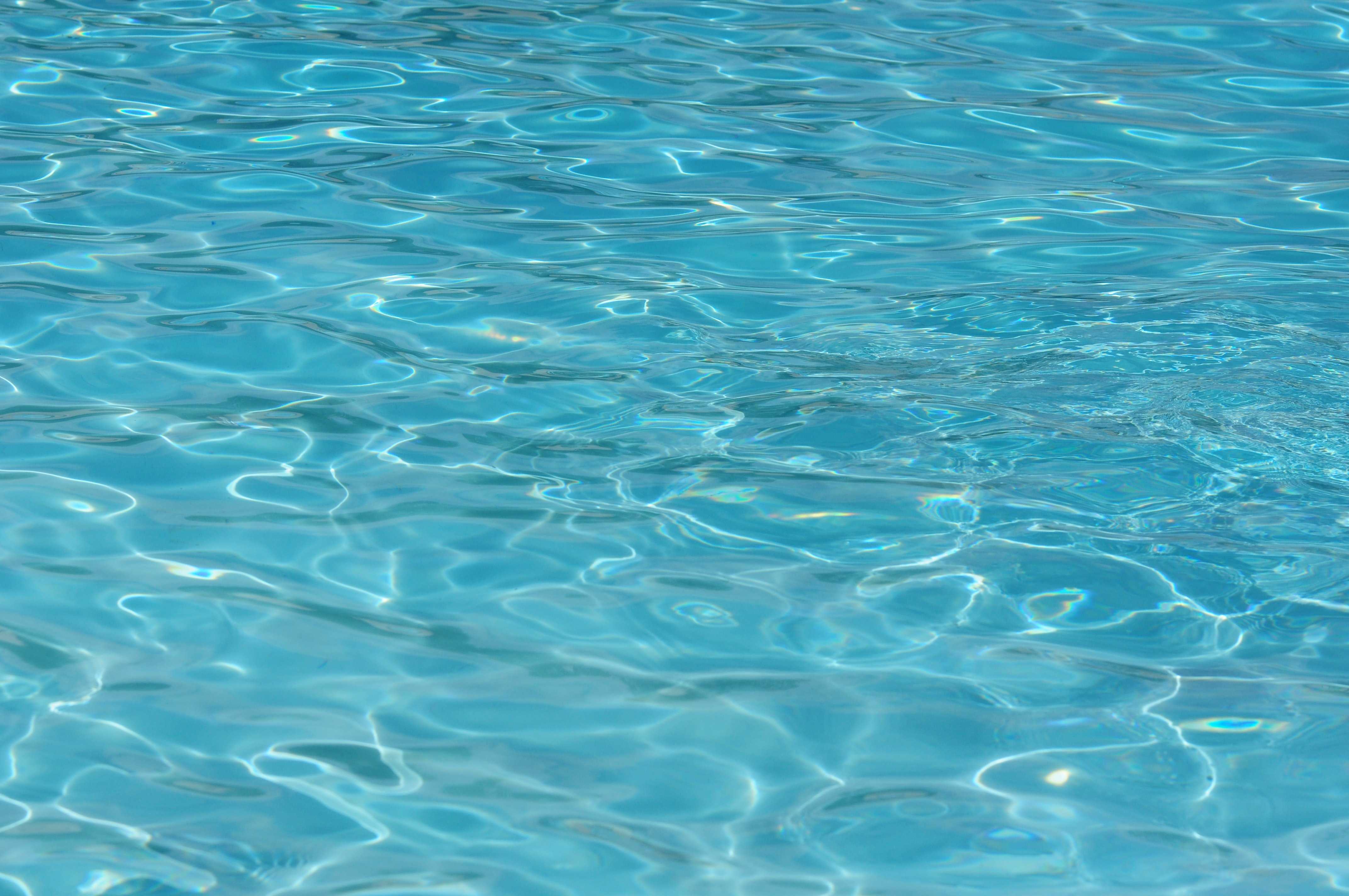 Close-up of rippling blue pool water with light reflections, calm and refreshing mood.